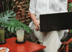 Kavézóban laptopon dolgozó nő